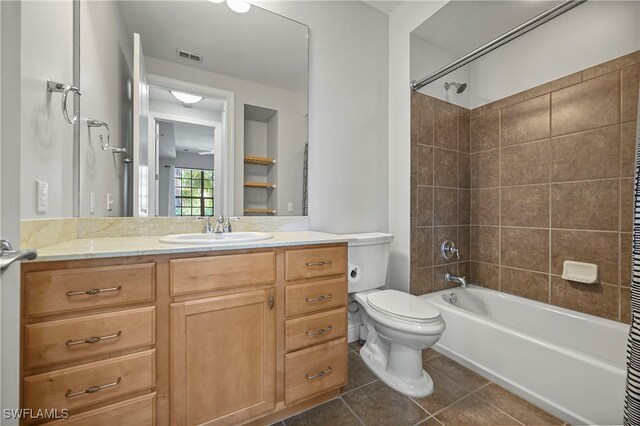 full bathroom with vanity, tiled shower / bath combo, toilet, and tile patterned flooring