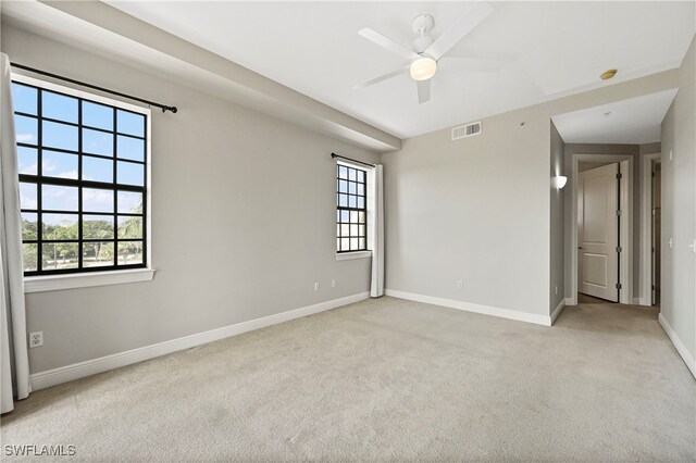 carpeted spare room featuring ceiling fan and a healthy amount of sunlight