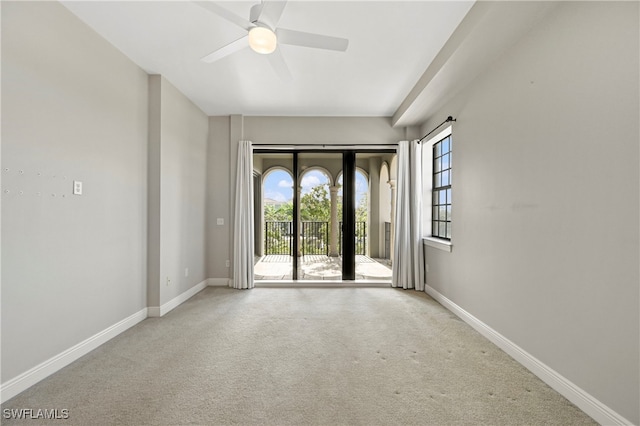 unfurnished room featuring a healthy amount of sunlight, baseboards, carpet floors, and ceiling fan