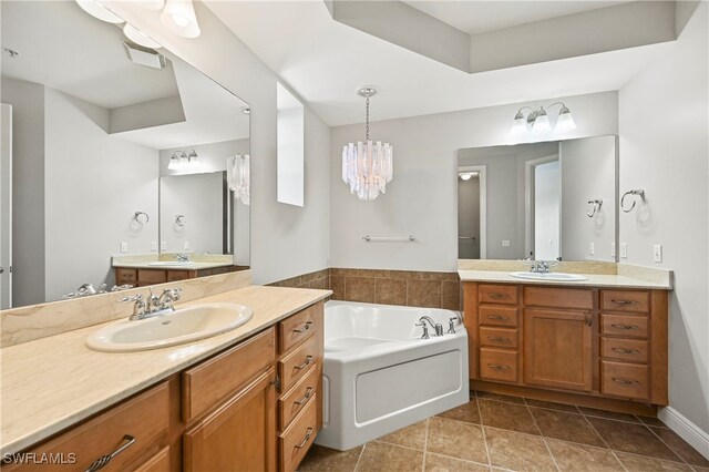 bathroom with a bathing tub, dual vanity, tile patterned flooring, and an inviting chandelier