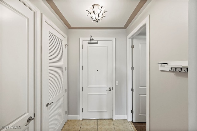 corridor featuring light tile patterned flooring and baseboards