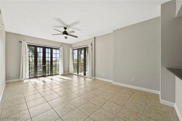 empty room with ceiling fan, french doors, and light tile patterned floors