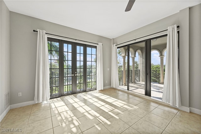 tiled empty room with visible vents, baseboards, and french doors