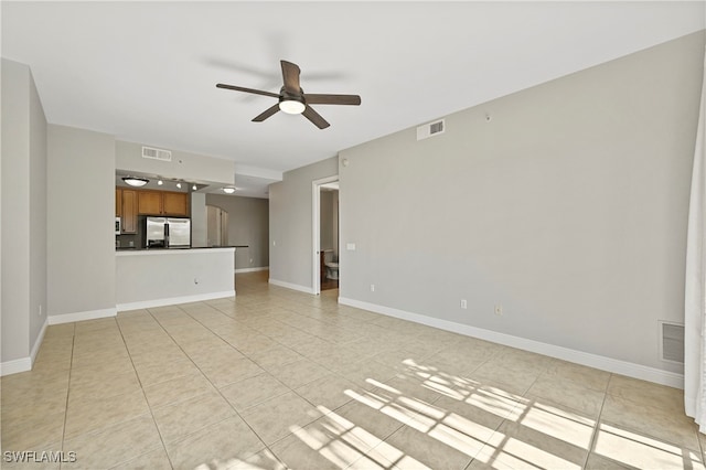 unfurnished living room with visible vents, ceiling fan, and baseboards