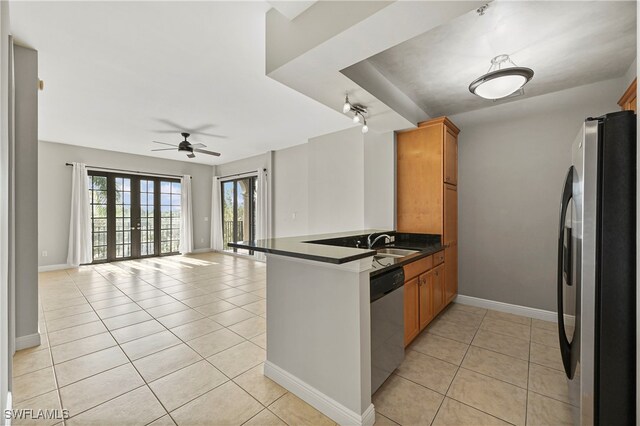 kitchen featuring appliances with stainless steel finishes, kitchen peninsula, light tile patterned floors, and ceiling fan