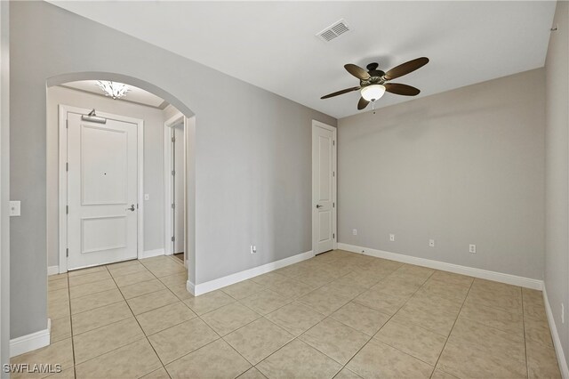 spare room with ceiling fan and light tile patterned floors