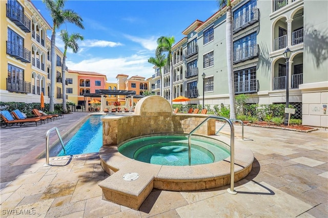 view of swimming pool featuring a residential view and a hot tub