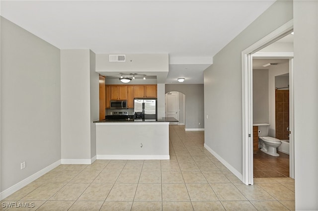 kitchen with light tile patterned flooring, appliances with stainless steel finishes, track lighting, ceiling fan, and kitchen peninsula