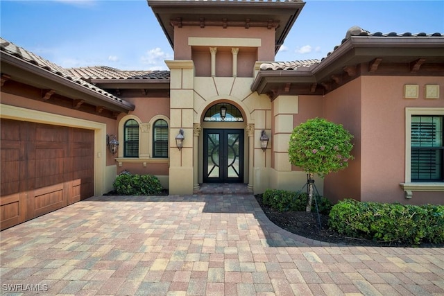 entrance to property featuring a garage and french doors