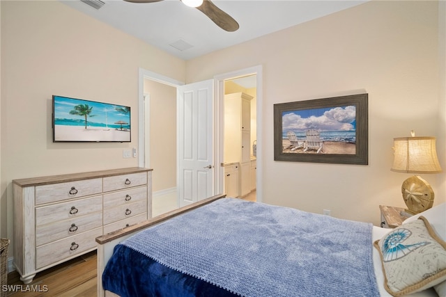 bedroom with connected bathroom, ceiling fan, and dark wood-type flooring