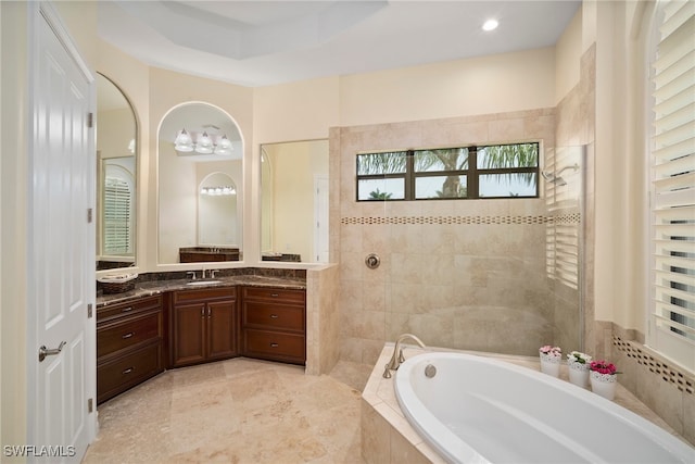 bathroom with separate shower and tub, a raised ceiling, and vanity