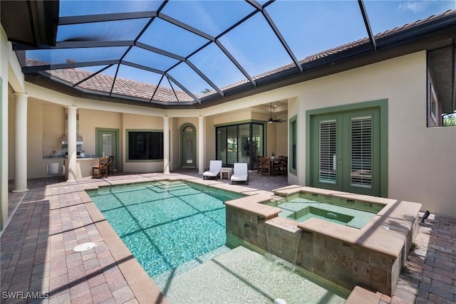 view of swimming pool featuring an in ground hot tub, glass enclosure, ceiling fan, and a patio area