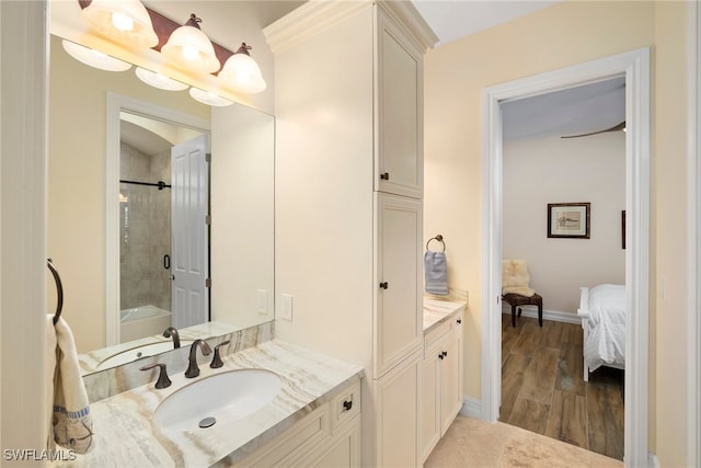 bathroom featuring vanity, wood-type flooring, and tiled shower / bath combo