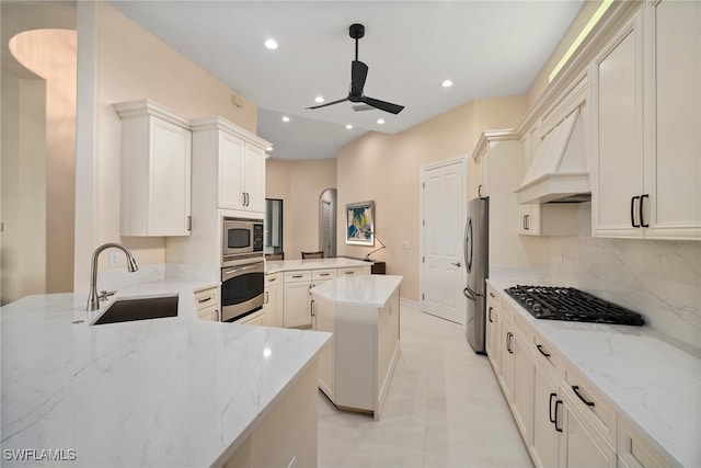 kitchen featuring a center island, sink, light stone countertops, and stainless steel appliances