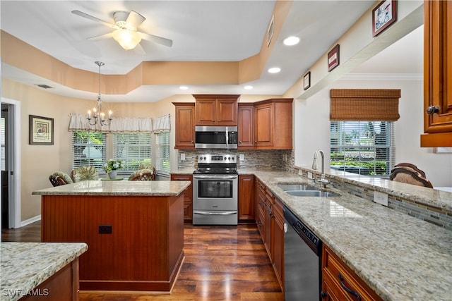 kitchen featuring stainless steel appliances, tasteful backsplash, dark hardwood / wood-style floors, a kitchen island, and light stone countertops