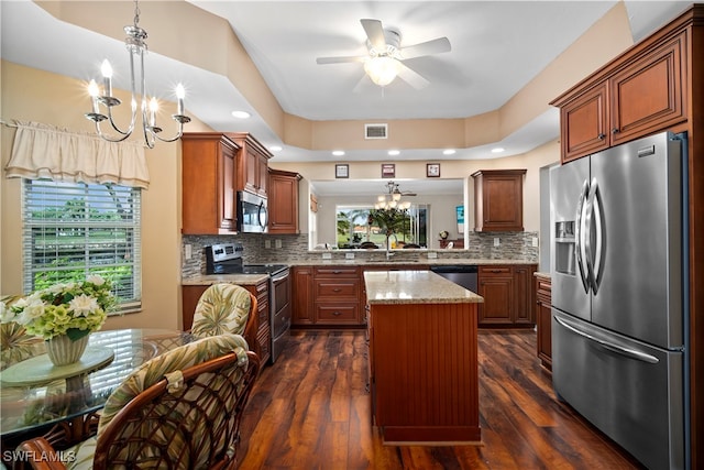 kitchen featuring stainless steel appliances, a kitchen island, dark wood-type flooring, pendant lighting, and decorative backsplash