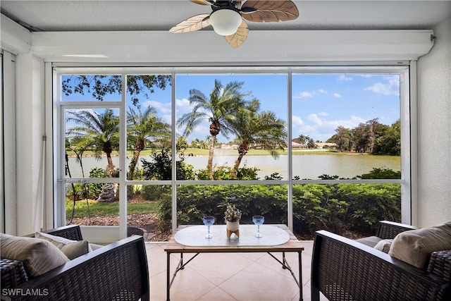 sunroom / solarium featuring ceiling fan and a water view