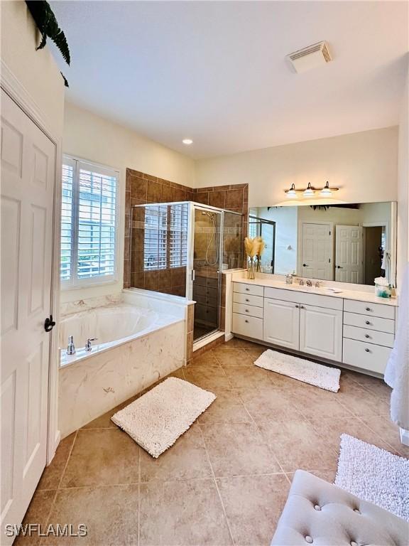 bathroom featuring vanity, plus walk in shower, and tile patterned floors