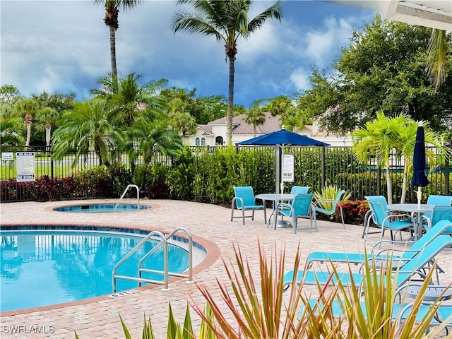 view of swimming pool with a patio area and a hot tub