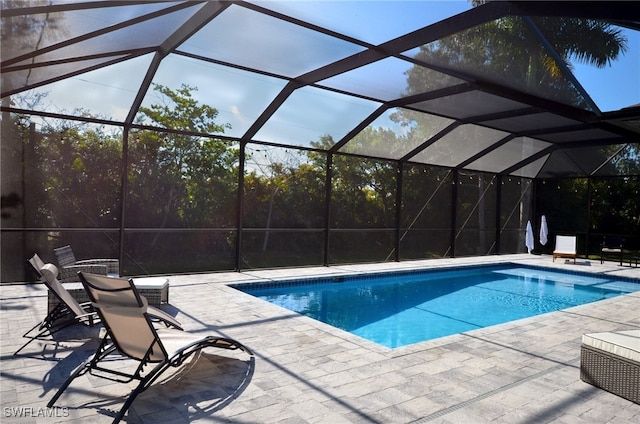 view of swimming pool with a patio area and glass enclosure