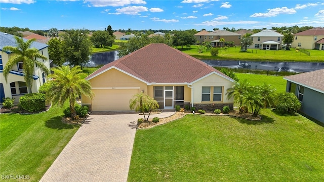 view of front of house featuring a garage, a water view, and a front yard