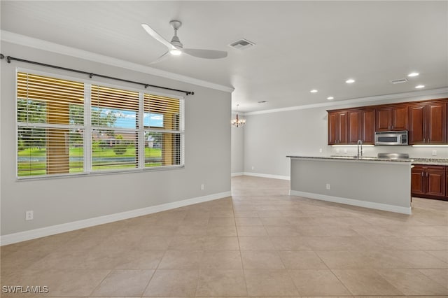 kitchen with decorative light fixtures, light tile patterned floors, crown molding, a kitchen island with sink, and ceiling fan with notable chandelier