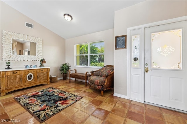 entryway with lofted ceiling and light tile patterned floors