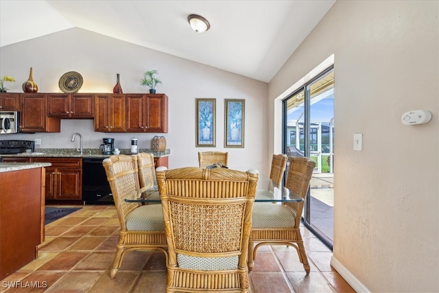 dining room featuring sink, tile patterned floors, and lofted ceiling