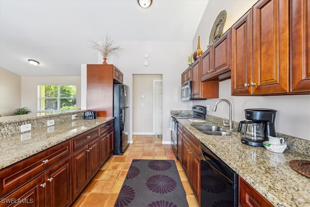 kitchen featuring sink, light stone countertops, black appliances, and light tile patterned floors