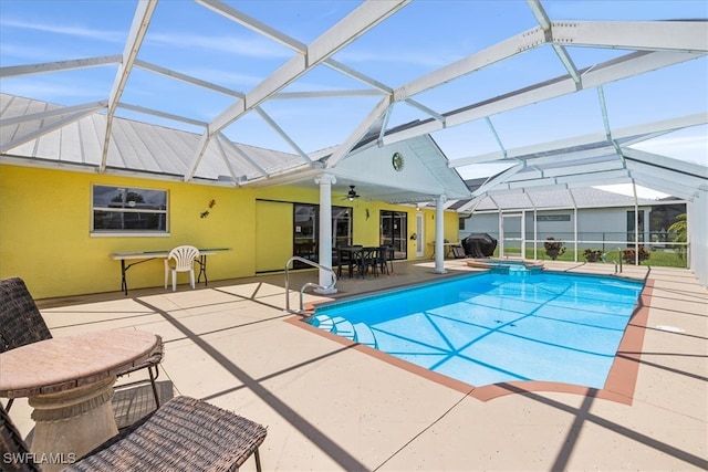 view of swimming pool with a patio area, ceiling fan, and glass enclosure