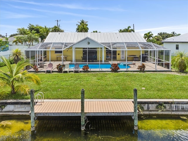 rear view of property with a lawn, a patio area, and a lanai