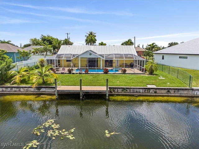 back of property featuring a water view, a lawn, and glass enclosure