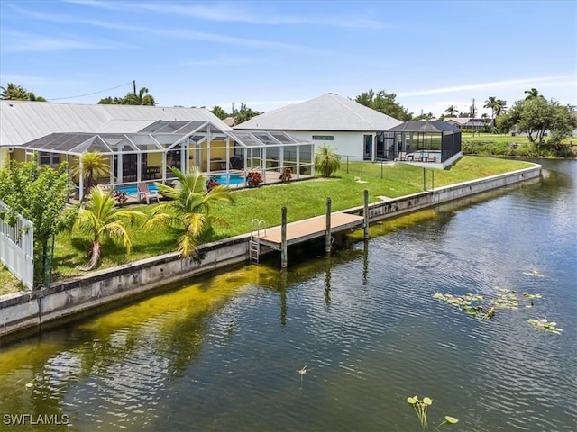 exterior space with a water view, a lawn, and a lanai