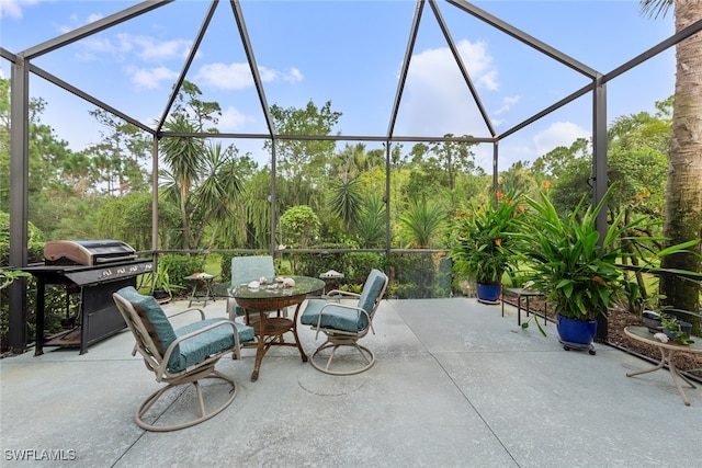 view of patio with glass enclosure and grilling area