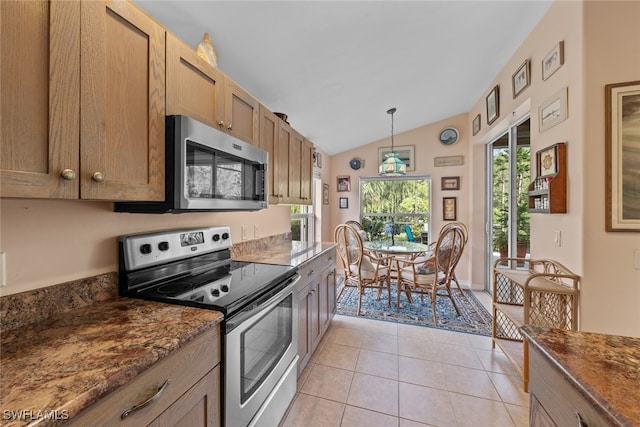 kitchen with stainless steel appliances, vaulted ceiling, light tile patterned floors, and a wealth of natural light