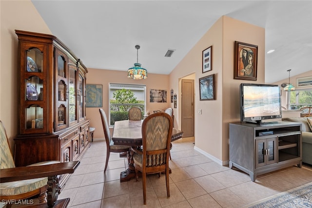 dining space with light tile patterned floors and lofted ceiling