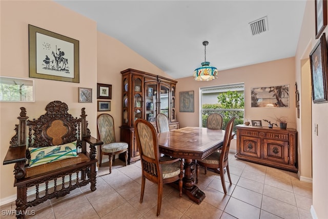 dining room with light tile patterned floors and vaulted ceiling