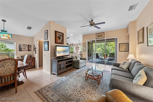 living room with ceiling fan, light tile patterned floors, and lofted ceiling