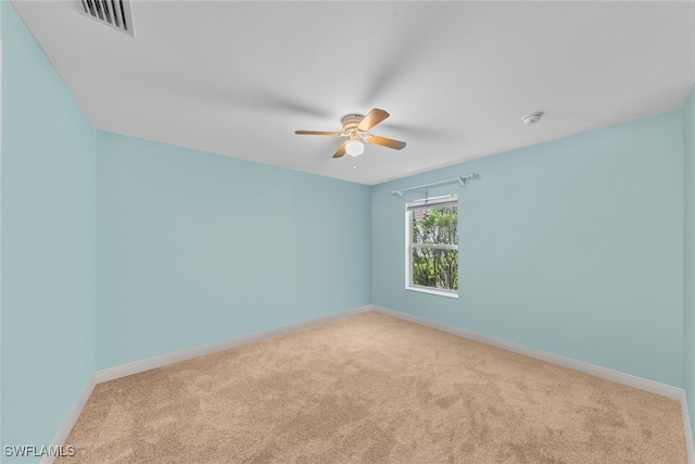 spare room with ceiling fan and light colored carpet