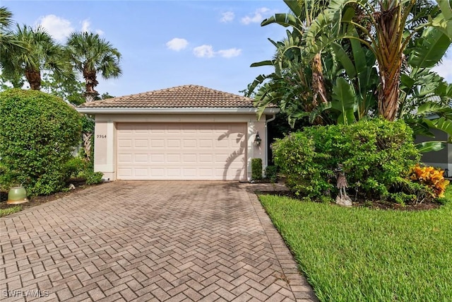 view of front of home featuring a garage, a tile roof, decorative driveway, and stucco siding