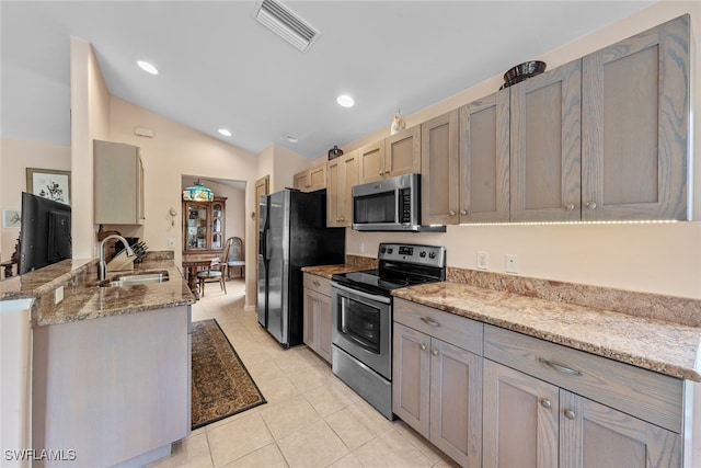 kitchen featuring appliances with stainless steel finishes, kitchen peninsula, light stone countertops, light tile patterned flooring, and sink