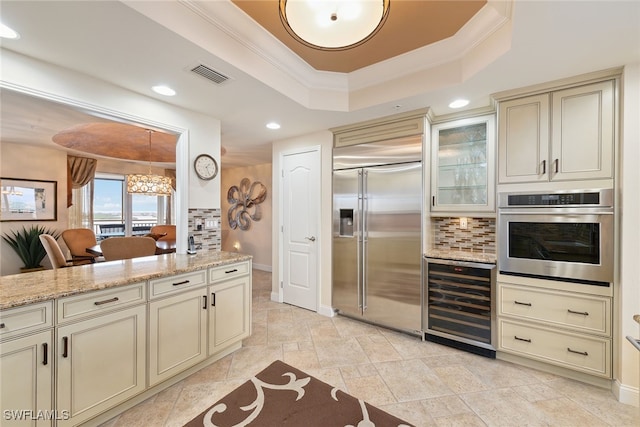 kitchen with wine cooler, cream cabinets, crown molding, and stainless steel appliances