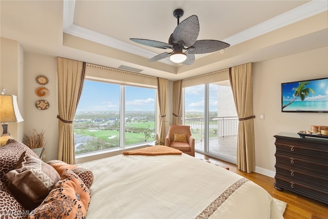 bedroom featuring access to exterior, ceiling fan, crown molding, a tray ceiling, and light hardwood / wood-style flooring