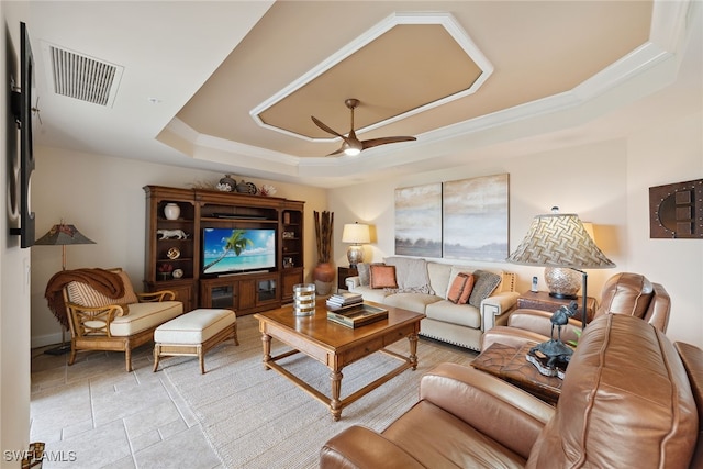 living room with ceiling fan and a raised ceiling