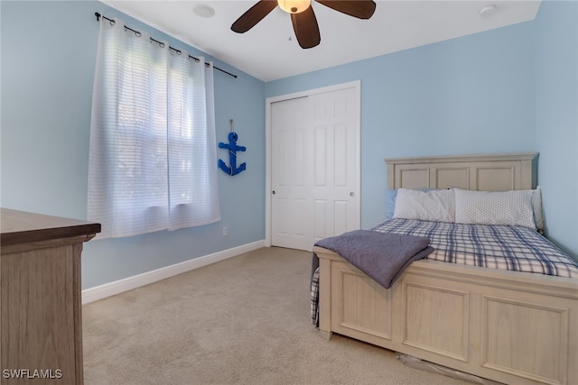 bedroom with light carpet, ceiling fan, and a closet