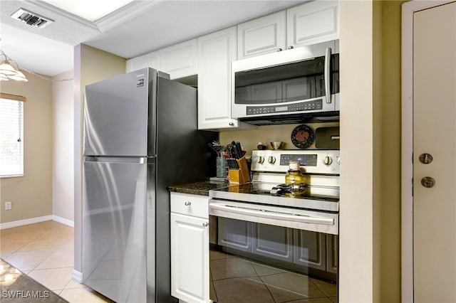 kitchen with stainless steel appliances, white cabinetry, and light tile patterned flooring