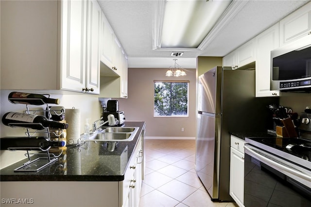 kitchen featuring sink, white cabinetry, an inviting chandelier, light tile patterned floors, and stainless steel appliances