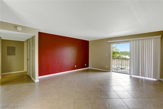 tiled spare room featuring electric panel and a textured ceiling