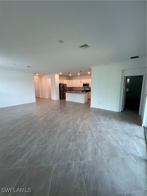 unfurnished living room featuring sink