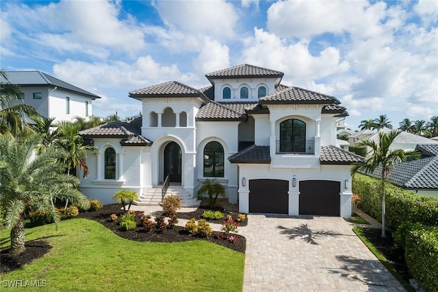 mediterranean / spanish-style house featuring a garage and a front lawn